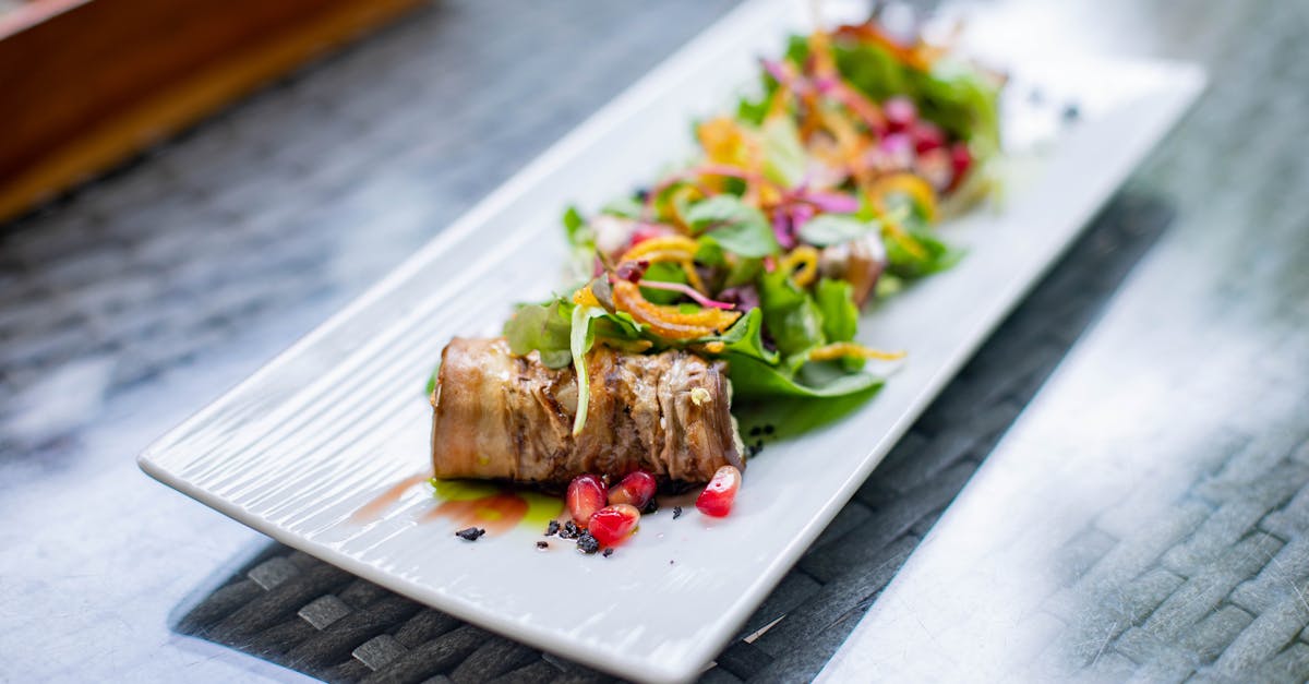 Delicious beef roulade served with a vibrant salad on a rectangular plate, ideal for gourmet food lovers.