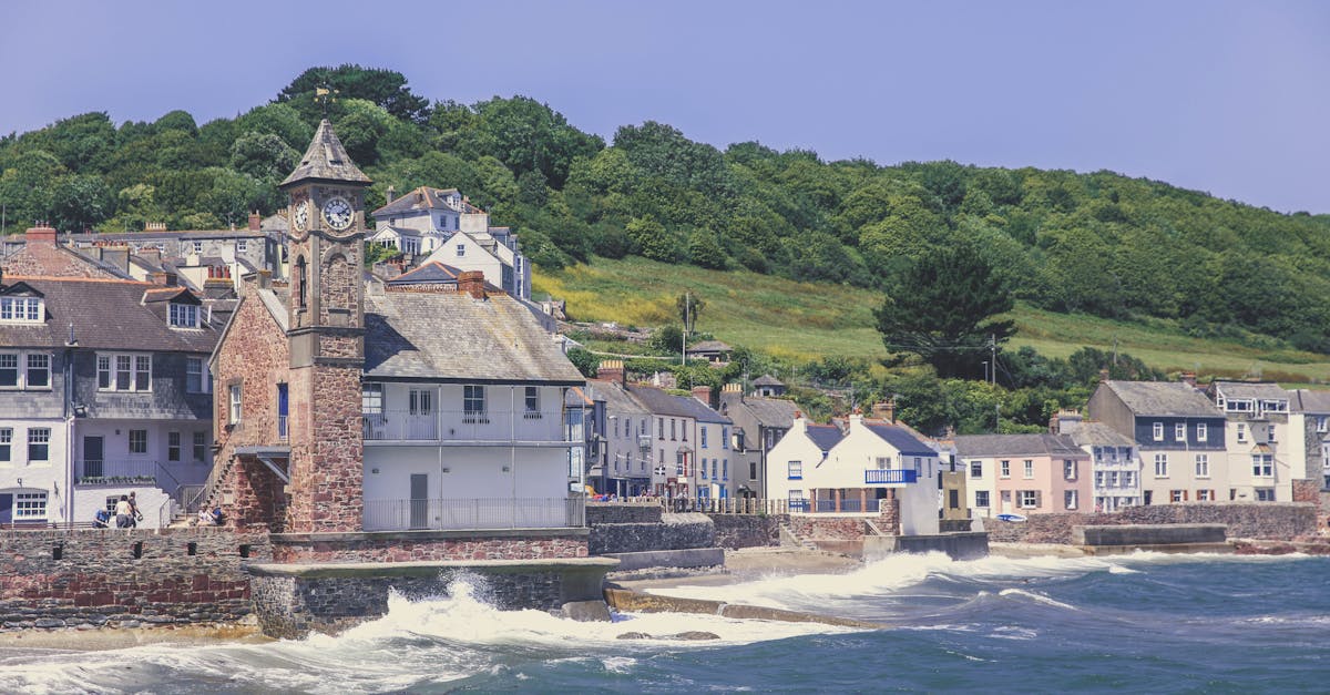 Charming coastal village scene with clock tower and colorful houses in Kingsand, UK.