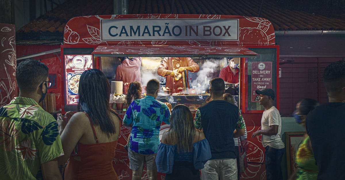 Crowds gather at a shrimp food truck in Porto de Galinhas for nighttime street food delight.